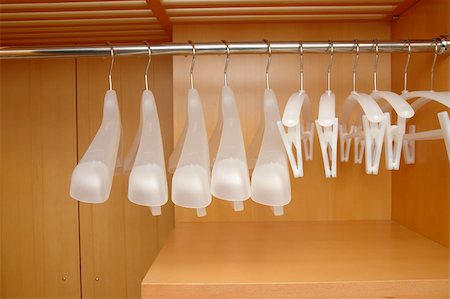 dresses closet - Empty clothes hangers hanging on a rail in closet Photographie de stock - Aubaine LD & Abonnement, Code: 400-05080998