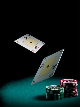 simsearch:400-06389082,k - Two aces flying over a green felt with three piles of different colors chips. Stockbilder - Microstock & Abonnement, Bildnummer: 400-05081217