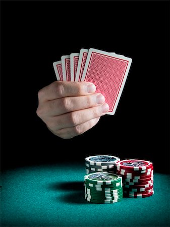 simsearch:400-06389082,k - A man's hand holding four cards over three piles of different colors chips on a green felt. Stockbilder - Microstock & Abonnement, Bildnummer: 400-05081218