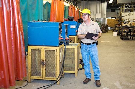 simsearch:400-04032937,k - Inspector checking the welding equipment in a metal works factory. Photographie de stock - Aubaine LD & Abonnement, Code: 400-05081985