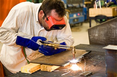 Worker using an acetylene torch to cut through metal in a metalworks factory. Stock Photo - Budget Royalty-Free & Subscription, Code: 400-05081994