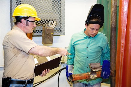 simsearch:400-04032937,k - Supervisor evaluating a metal worker on the factory floor. Photographie de stock - Aubaine LD & Abonnement, Code: 400-05081990