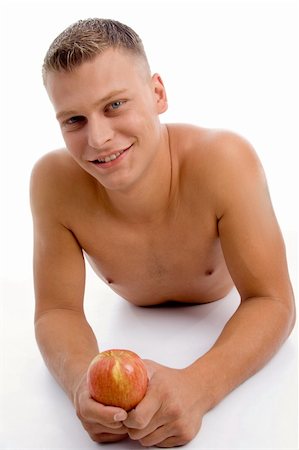 physical fit food - laying fit guy with apple on an isolated white background Stock Photo - Budget Royalty-Free & Subscription, Code: 400-05082991