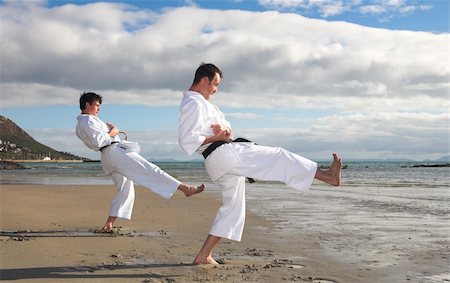 play fight - Young adult men with black belt practicing a Kata on the beach on a sunny day Foto de stock - Super Valor sin royalties y Suscripción, Código: 400-05083175