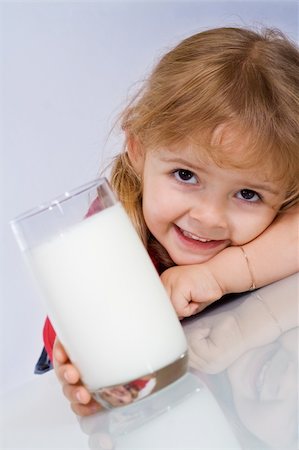 simsearch:400-04218582,k - Happy little girl reaching for a glass of milk Stockbilder - Microstock & Abonnement, Bildnummer: 400-05083789