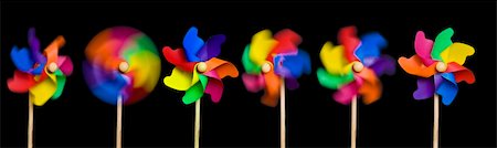 Blowing in the Wind: toy windmills spinning at various speeds from stationary to fast; isolated on easily-extendable black ground to give good copy-space; high resolution so each image can be used on its own Stock Photo - Budget Royalty-Free & Subscription, Code: 400-05083935