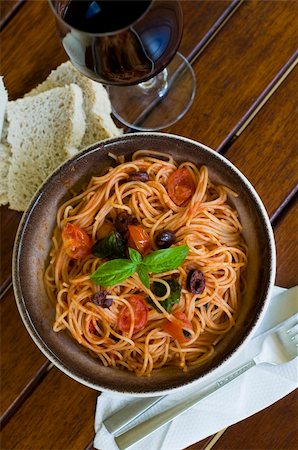 simsearch:400-06461717,k - A plate of spaghetti with italian sauce, served with red wine, bread and olives on a wooden table Stock Photo - Budget Royalty-Free & Subscription, Code: 400-05094361