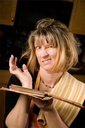 frustrated cook - Harried woman in residential kitchen with recipe book Stock Photo - Budget Royalty-Free & Subscription, Code: 400-05094488