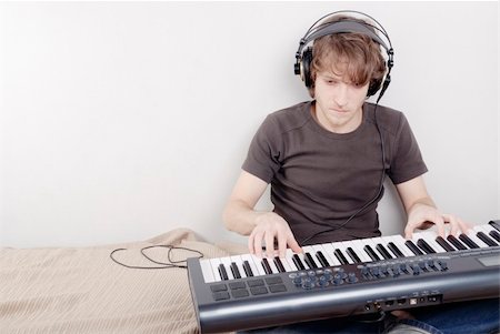 Game process on a MIDI-keyboard, man in headphones Foto de stock - Super Valor sin royalties y Suscripción, Código: 400-05094519