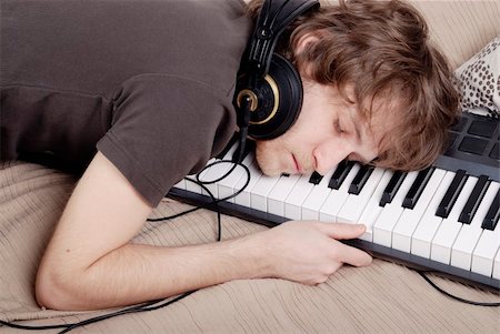 Man in the brown T-shirt asleep on the MIDI-keyboard Foto de stock - Super Valor sin royalties y Suscripción, Código: 400-05094521