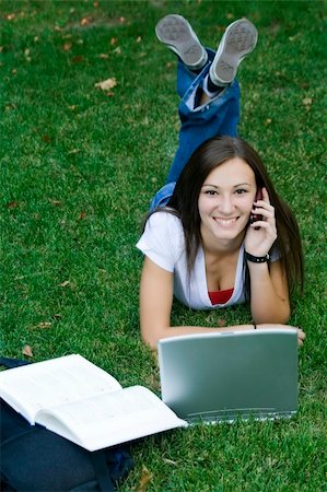 Cute teen girl laying down on the grass studying with her laptop Stock Photo - Budget Royalty-Free & Subscription, Code: 400-05097009