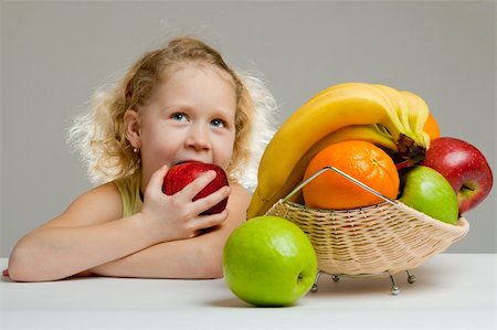Lovely little girl eating a big red apple Photographie de stock - Aubaine LD & Abonnement, Code: 400-05097808