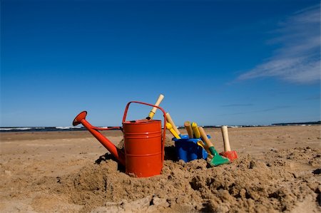 sandbox - Red watering can, plastic blue bucket and other beach toys in the sandy seashore Stock Photo - Budget Royalty-Free & Subscription, Code: 400-05098266