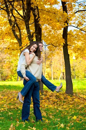 Happy young couple play piggyback in the autumn park Stock Photo - Budget Royalty-Free & Subscription, Code: 400-05098304