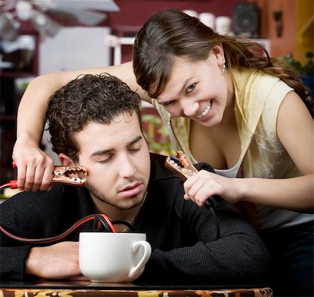 electricity humor - Young woman holding jumper cables coming out of coffee mug to man's head Stock Photo - Budget Royalty-Free & Subscription, Code: 400-05090529