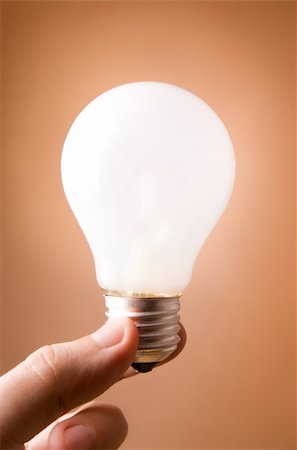 simsearch:640-01354128,k - Man's hand holding light bulb on the beige background Photographie de stock - Aubaine LD & Abonnement, Code: 400-05090868