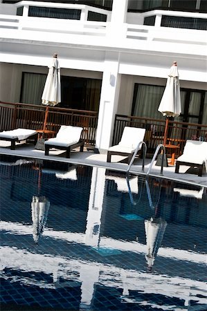 simsearch:400-03961189,k - Swimming pool with deck chairs and umbrellas at a tropical resort. Fotografie stock - Microstock e Abbonamento, Codice: 400-05091305