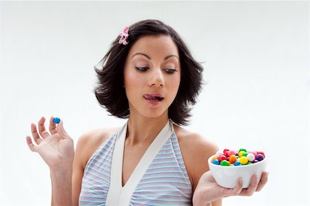 Happy beautiful candy girl with a bowl of colorful bubblegum candy balls licking her lip, isolated Stock Photo - Budget Royalty-Free & Subscription, Code: 400-05091669