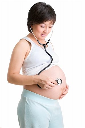 A mother to be is placing the stethoscope on her stomach to listen to the baby?s voice. Shot against white background Stock Photo - Budget Royalty-Free & Subscription, Code: 400-05091942