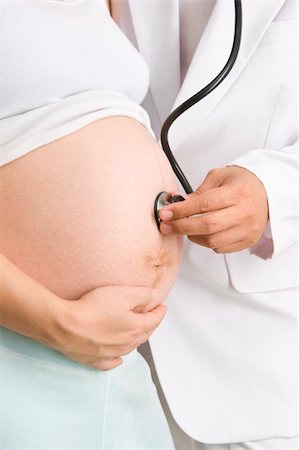 A doctor is checking the baby's health in a mother's womb. Shot against white background. Stock Photo - Budget Royalty-Free & Subscription, Code: 400-05091943