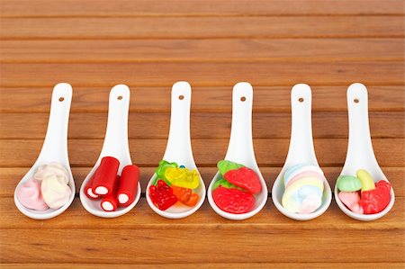 simsearch:400-06135772,k - Assortment of candies in the spoons with soft shadow in the wooden background Fotografie stock - Microstock e Abbonamento, Codice: 400-05092435