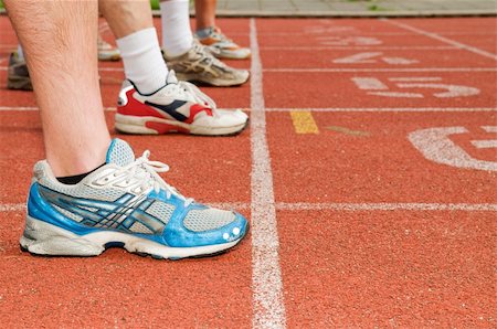 Four pair of feet and running shoes ready for the start of a run Fotografie stock - Microstock e Abbonamento, Codice: 400-05093162