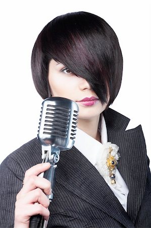 simsearch:400-05094854,k - Young woman with fashion haircut holding a vintage microphone, on white Photographie de stock - Aubaine LD & Abonnement, Code: 400-05093356