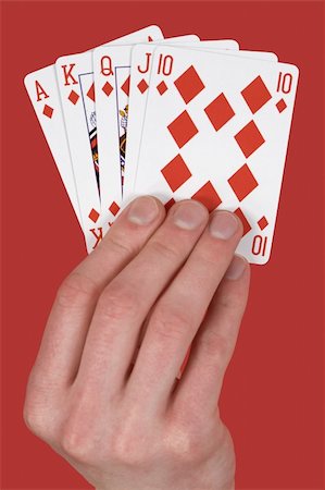 Playing cards single suit in hand on red Stockbilder - Microstock & Abonnement, Bildnummer: 400-05105361