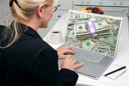 simsearch:400-05129327,k - Woman In Kitchen Using Laptop to Earn or Win Money. Screen can be easily used for your own message or picture. Picture on screen is my copyright as well. Stock Photo - Budget Royalty-Free & Subscription, Code: 400-05106608