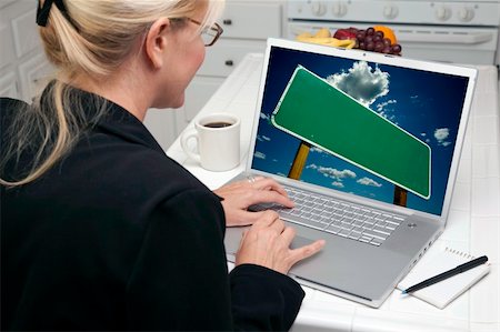 simsearch:400-06857713,k - Woman In Kitchen Using Laptop with Blank Road Sign Ready for Your Own Message. Screen can be easily used for your own message or picture. Picture on screen is my copyright as well. Fotografie stock - Microstock e Abbonamento, Codice: 400-05106610
