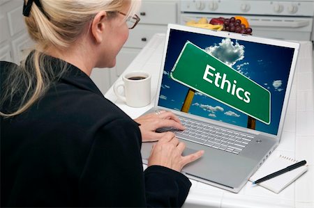 simsearch:400-06857713,k - Woman In Kitchen Using Laptop with Ethics Road Sign on Screen. Screen can be easily used for your own message or picture. Picture on screen is my copyright as well. Fotografie stock - Microstock e Abbonamento, Codice: 400-05106611