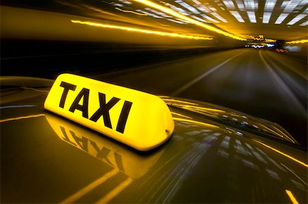 A cab at high speed on a motorway in an urban area with the lit taxi sign on top of its roof Stock Photo - Budget Royalty-Free & Subscription, Code: 400-05106629
