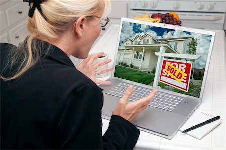 simsearch:400-06857713,k - Excited Woman In Kitchen Using Laptop to Sell or Buy a Home. Screen can be easily used for your own message or picture. Picture on screen is my copyright as well. Fotografie stock - Microstock e Abbonamento, Codice: 400-05106632