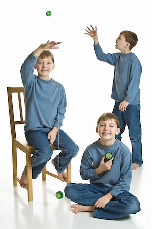 Three matching boys in blue playing with yo-yos. Isolated on a white background. Foto de stock - Royalty-Free Super Valor e Assinatura, Número: 400-05109121