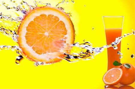 simsearch:400-04392468,k - View of piece of orange getting splashed  and  glass of juice on back Photographie de stock - Aubaine LD & Abonnement, Code: 400-05100195