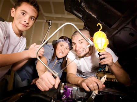 Hapless family of mechanics working on car with all the wrong tools Stock Photo - Budget Royalty-Free & Subscription, Code: 400-05101575
