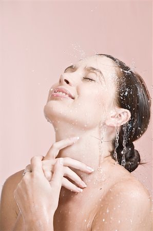 simsearch:400-05112444,k - Portrait of young beautiful woman  getting splashed on pink background Stock Photo - Budget Royalty-Free & Subscription, Code: 400-05114209