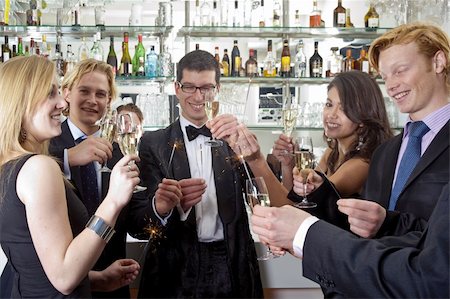 several people toasting with champagne on new years eve while holding sparkling sticks Photographie de stock - Aubaine LD & Abonnement, Code: 400-05114512