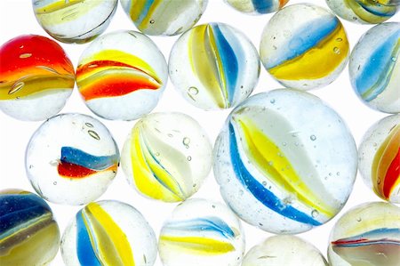 Collection of Cats Eye Marbles including Shooter on a Light Table Stock Photo - Budget Royalty-Free & Subscription, Code: 400-05115185