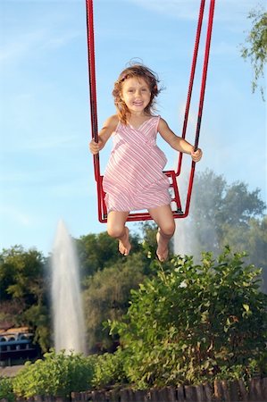 Happy little girl swinging high in the sky over fountains Stock Photo - Budget Royalty-Free & Subscription, Code: 400-05115467