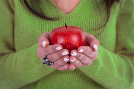young woman holding healthy red apple in the hands - focus on the apple Photographie de stock - Aubaine LD & Abonnement, Code: 400-05116034