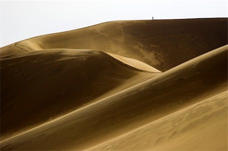 People small like aints walking far-away in dunes with sand being blown over by wind Stockbilder - Microstock & Abonnement, Bildnummer: 400-05116767