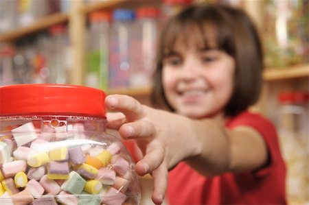 spoiled for choice - young girl grabbing a jar of sweets in shop Stock Photo - Budget Royalty-Free & Subscription, Code: 400-05117206