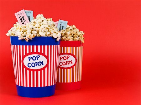 simsearch:400-04913050,k - Two popcorn buckets over a red background. Movie stubs sitting over the popcorn. Photographie de stock - Aubaine LD & Abonnement, Code: 400-05117609