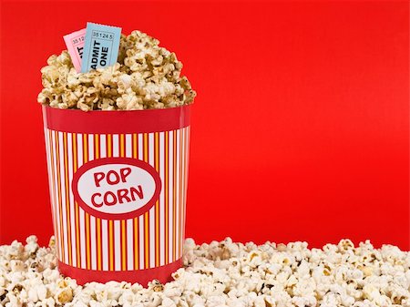 simsearch:400-04913050,k - A popcorn bucket over a red background. Movie stubs sitting over the popcorn. Photographie de stock - Aubaine LD & Abonnement, Code: 400-05117610