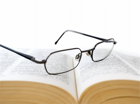 Closeup of opened book with glasses on it, on white background,shallow DOF,focus on glasses Stock Photo - Budget Royalty-Free & Subscription, Code: 400-05119318