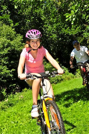 parent and teen bikes - Teenage girl and her father riding bicycles in summer park Stock Photo - Budget Royalty-Free & Subscription, Code: 400-05111321
