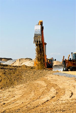 simsearch:400-05111345,k - Yellow bulldozer machines digging and moving earth at construction site Fotografie stock - Microstock e Abbonamento, Codice: 400-05111345