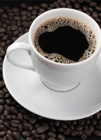 simsearch:400-04305840,k - Cup of coffee. A background with coffee grains and a white cup. A photo close up Foto de stock - Super Valor sin royalties y Suscripción, Código: 400-05112260