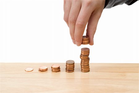 dragon_fang (artist) - Stacks of pennies growing progressively higher with a hand adding more to the highest one, with copyspace Fotografie stock - Microstock e Abbonamento, Codice: 400-05113006